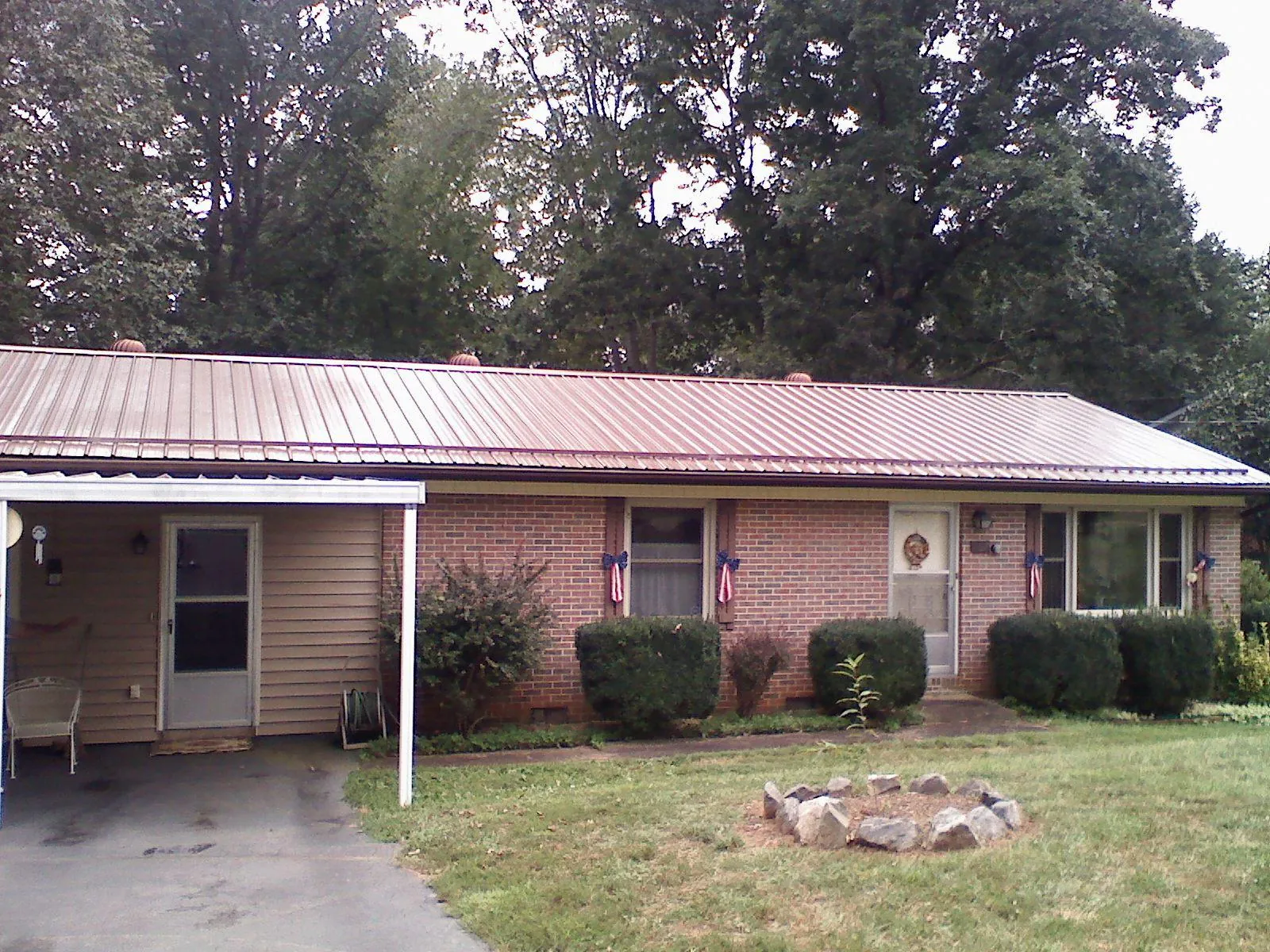 Bronze metal roof and carport on a brick ranch home — Roof Repair work by our crew in Burke