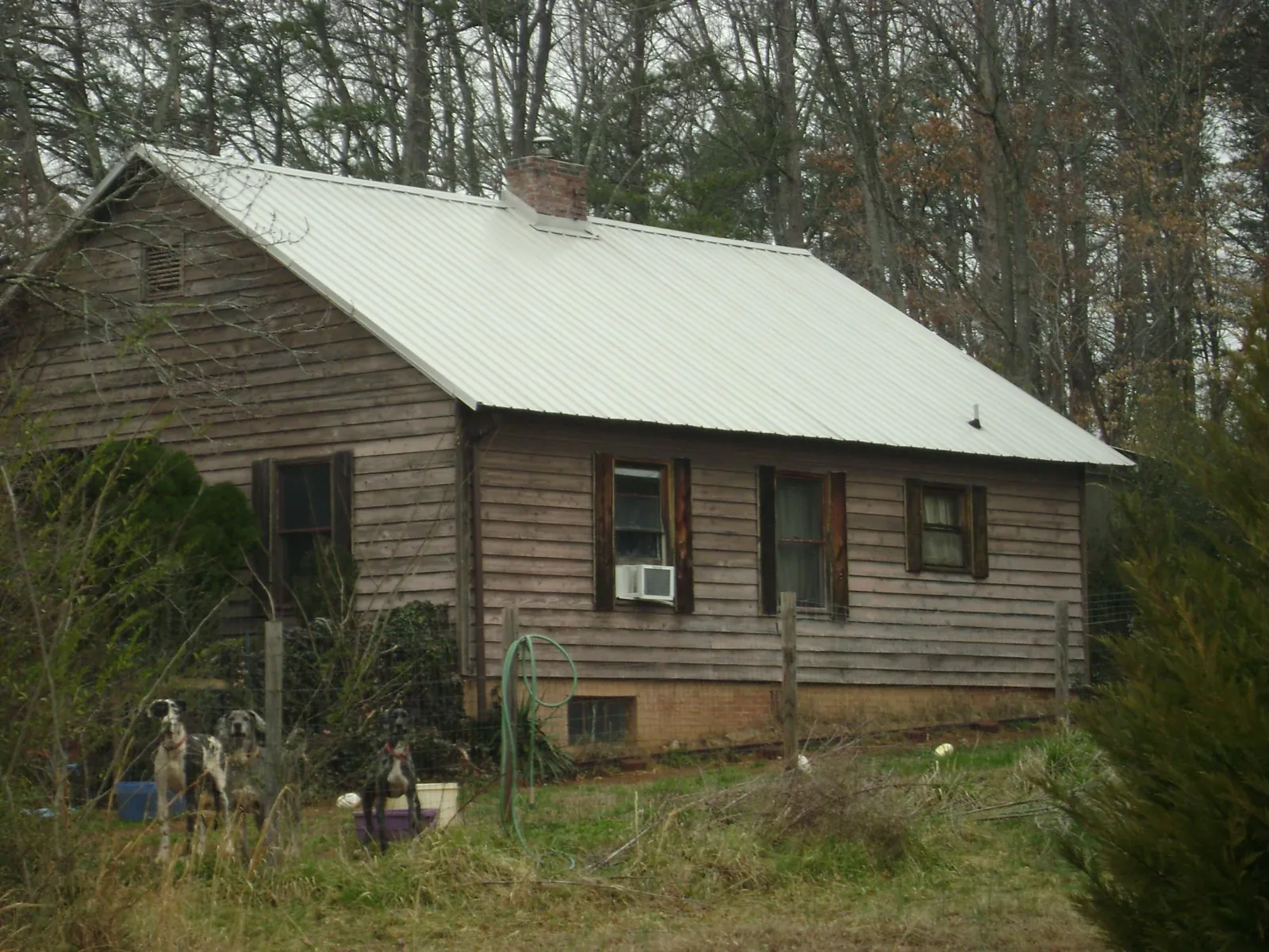 White metal roof on an old wood sided farmhouse, from a Metal Roof Installation job in Burke